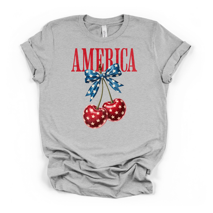 Athletic heather t-shirt with a patriotic graphic of two red star-print cherries tied with a blue star bow and America printed in red above
