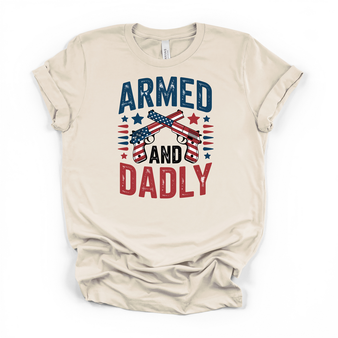 Armed and Dadly funny patriotic dad t-shirt in natural with distressed crossed American flag pistols graphic in red white and blue