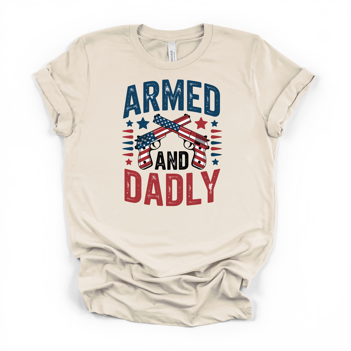 Armed and Dadly funny patriotic dad t-shirt in natural with distressed crossed American flag pistols graphic in red white and blue