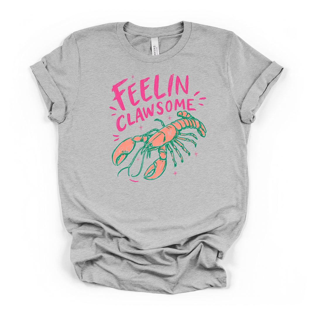 Athletic heather t-shirt featuring a fun coral and teal lobster illustration with pink sparkles and Feelin Clawsome text printed on the front