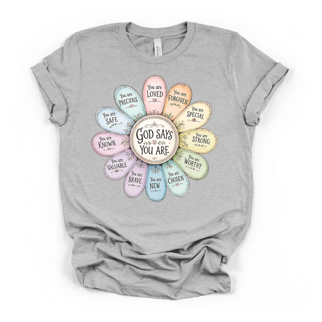 Athletic heather t-shirt with a pastel daisy graphic containing Christian affirmations on each petal including loved brave worthy and chosen with God Says You Are centered
