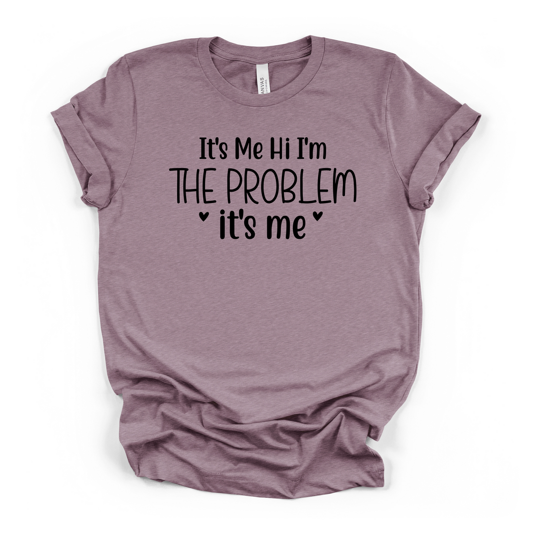 It's Me Hi I'm The Problem funny women's t-shirt in heather purple with playful black typography and heart accents