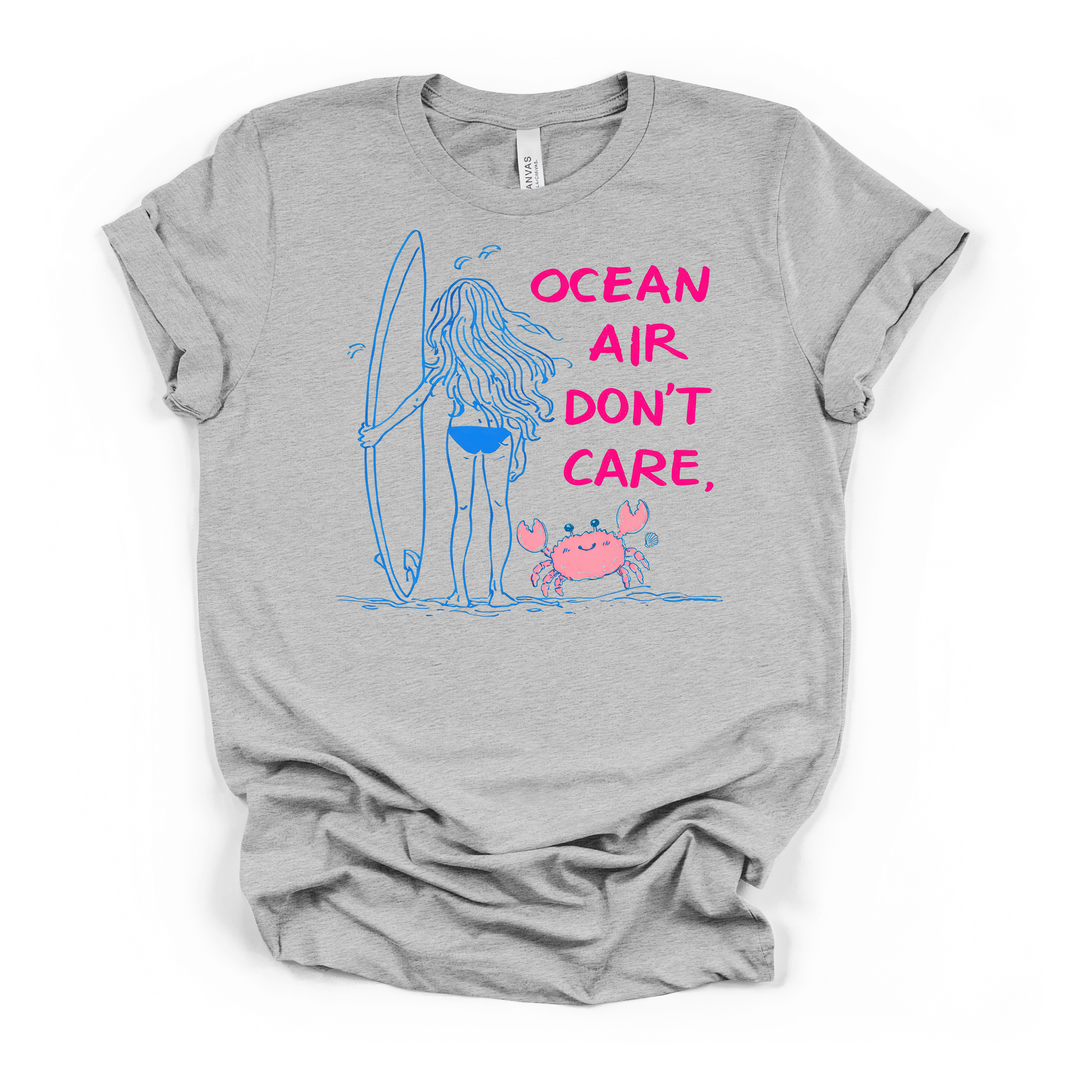 Ocean Air Don't Care surfer girl beach graphic t-shirt in athletic heather with blue line art illustration and hot pink lettering