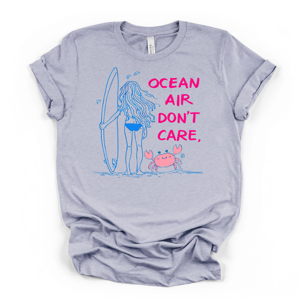 Ocean Air Don't Care surfer girl beach graphic t-shirt in heather blue with blue line art illustration and hot pink lettering