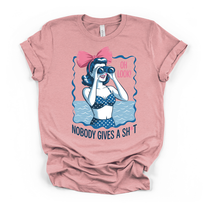 Heather pink t-shirt with a retro-style pin-up woman holding binoculars in a polka dot bikini with Oh Look Nobody Gives a Sht text below