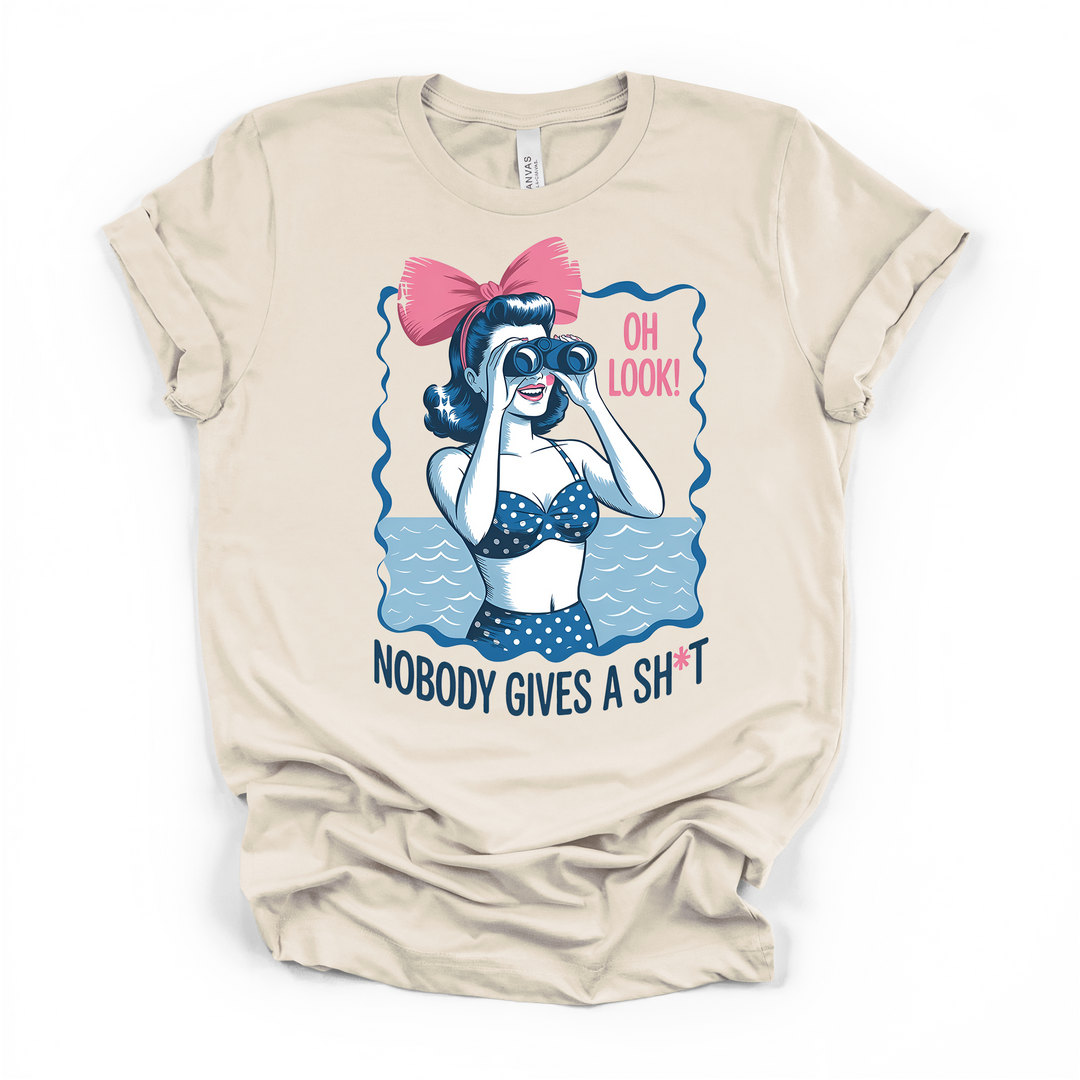 Natural cream t-shirt with a vintage pin-up woman in a polka dot swimsuit looking through binoculars and Oh Look Nobody Gives a Sht printed on the front