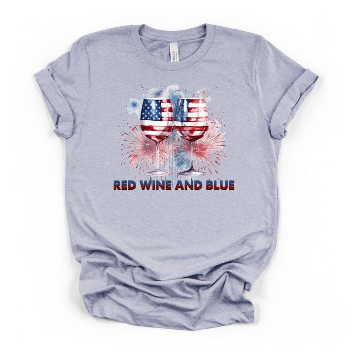 Heather blue t-shirt with patriotic American flag wine glasses and watercolor fireworks graphic and Red Wine and Blue text on the front