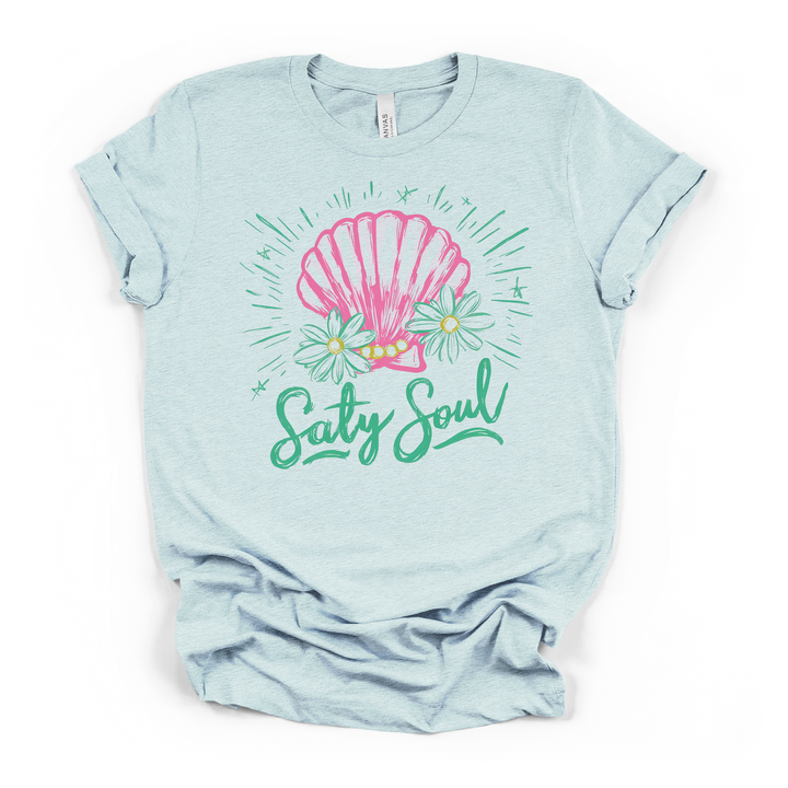 Alt Text: Salty Soul seashell graphic t-shirt in heather ice blue, featuring pink shell, daisies, and teal script lettering