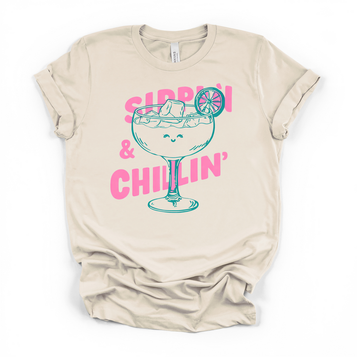 Sippin and Chillin cocktail graphic t-shirt in natural with smiling margarita glass and bold pink lettering