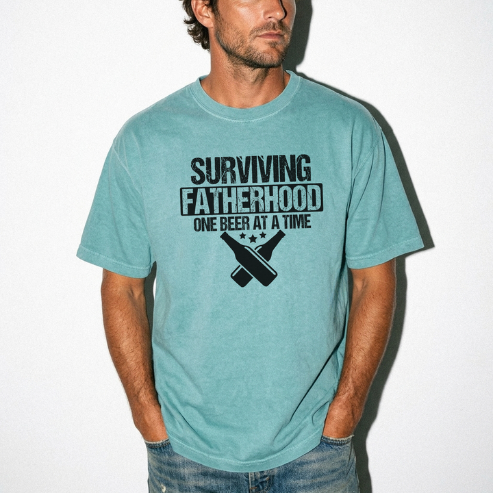 Surviving fatherhood one beer at a time funny dad shirt in seafoam