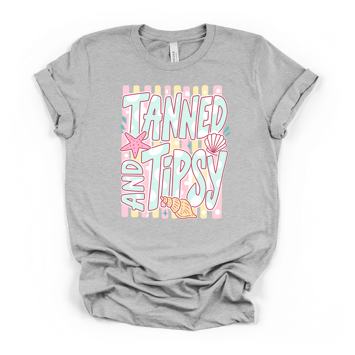 Athletic heather t-shirt with a pastel striped Tanned and Tipsy beach graphic featuring retro lettering a starfish and seashells on the front