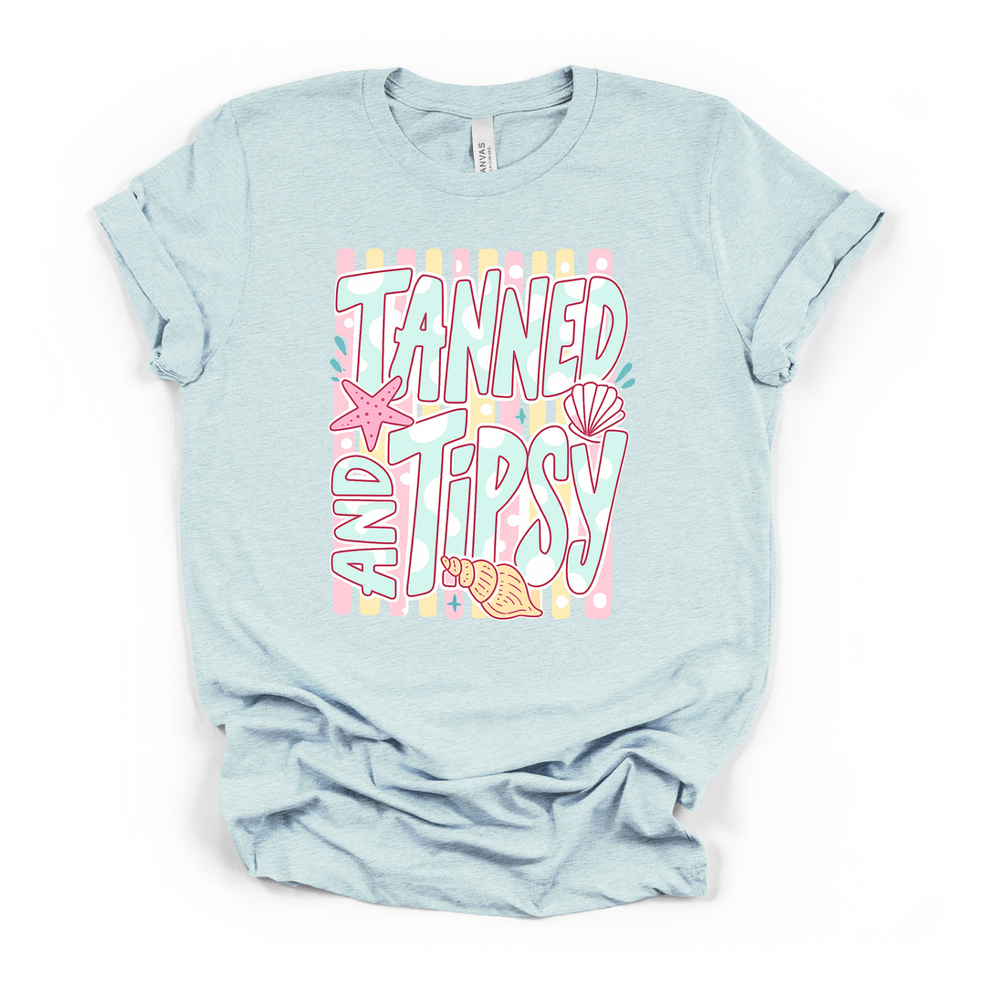 Heather ice blue t-shirt with a fun pastel Tanned and Tipsy retro beach graphic with seashells starfish and a striped dotted background