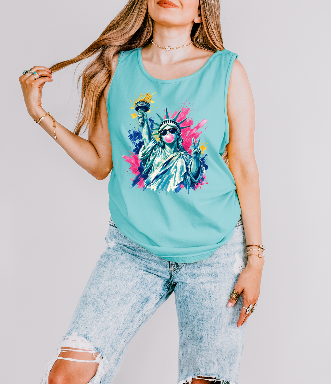 Bubblegum Liberty patriotic tank top in Chalky Mint with a pop art Statue of Liberty wearing sunglasses blowing bubblegum and flashing a peace sign