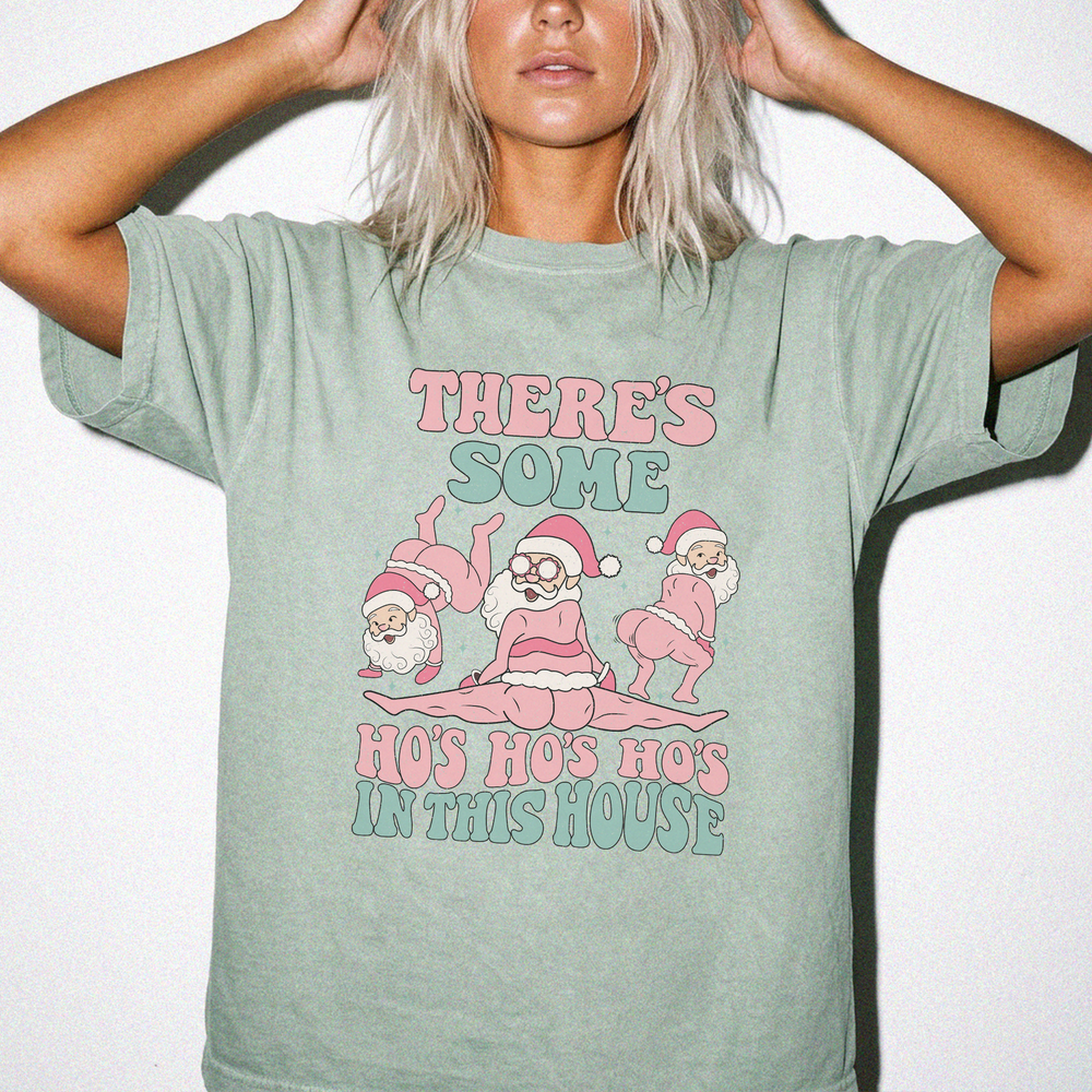 Theres Some Ho Ho Hos in This House funny Christmas shirt in Bay green with three dancing retro Santas and pink and teal retro text