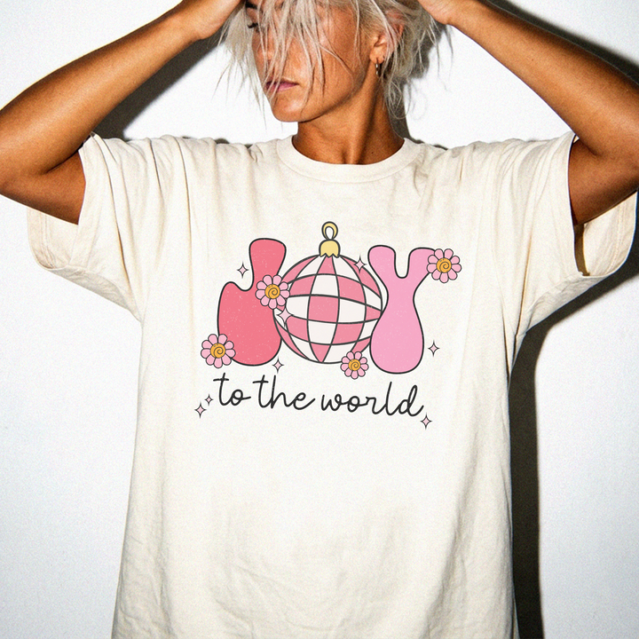 Joy to the World Christmas shirt in Ivory with retro pink JOY letters, a checkered ornament, and daisy accents