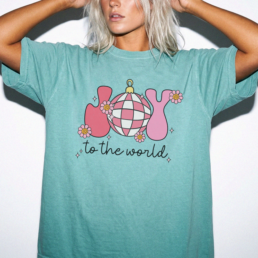 Joy to the World Christmas shirt in Seafoam with retro pink JOY letters, a checkered ornament, and daisy accents